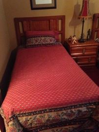 One of two twin beds; matching nightstand