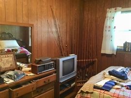Fishing rods, dresser, bed, clothing, tv