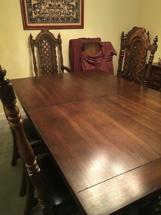 Elaborate solid pecan wood dining table with 10 chairs and 3 leaf inserts.