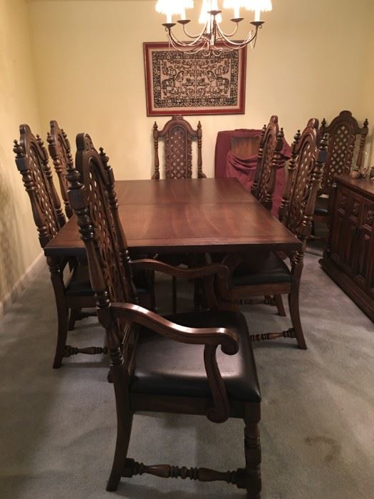 Elaborate solid pecan wood dining table with 10 chairs and 3 leaf inserts.
