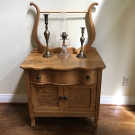 Antique oak washstand with serpentine drawer and towel rack.
