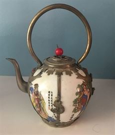 #2153: Unusual, Asian Art Porcelain with Metal Work Tea Pot
Beautiful Asian Art round shape porcelain teapot with decorative filigree metalwork overlay with rounded handle.

6.5"H