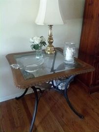 Glass table framed in  ruffled oak pattern with wrought iron legs.  All glassware and other decorations for sale as well.