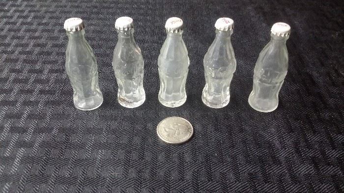 Mini glass Coke bottles with tin caps.