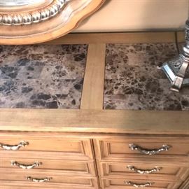 Marble inlaid on top of dresser.