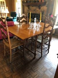 Vintage Colonial American maple dinning table with butterfly drop leaf, circa 1960.   A set of four vintage colonial style ladder backs chairs.