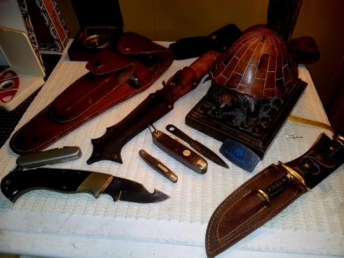 Knives including Old Timer Peanut, Remington UMC multi-tool, Mueler Spain, Pac-Saw, Pacific Cutlery Samson, & more. Turtle is the base of a table lamp.