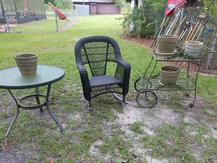 Rocker (wicker type), outdoor table, metal tea cart, & flower pots.
