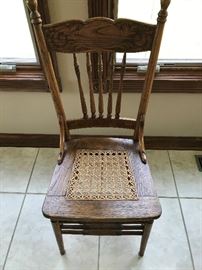 One of 6  cane bottom dining chairs with the antique tiger claw oak table