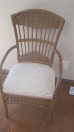 One of six rattan chairs with upholstered bottoms for glass top table