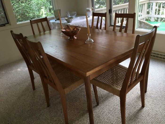 Teak dining table with pull out leaf each end  w/ set of 6 woven seat chairs - From Scandinavian Design.