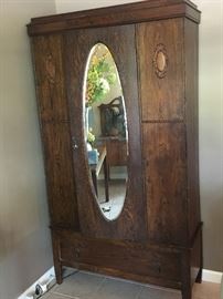 Lovely old cross grain oak armoire/ wardrobe with oval beveled mirror  storage for clothes or china or electronics (it has been converted back and forth) Measures 6' 5" by 42" across. Appears to come apart.