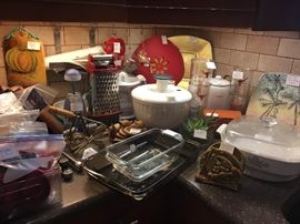 Kitchen: salad spinner, Corning, Pyrex, KitchenAid cheese grater, fishing reel napkin holder, Longhorn Tervis drinking glasses, utensils, cutting boards