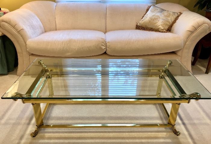 Carson's upholstered sofa and cocktail table with brass base and thick glass top.