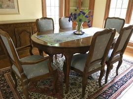 Baker Furniture hand carved dining room table with 6 chairs. Auction lot also includes 2 leaves for table.