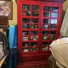 red cabient with glass doors and drawers for storage at the bottom 