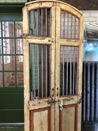 Set of painted antique wood doors with curved top and great iron details. Sliding lock with hinges on front. 6'-10"H x 2'-8"W (width does not include metal hardware sticking out) $525