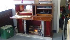 inside of novelty fireplace, left side bar, right side working record player, radio and 8 track player 