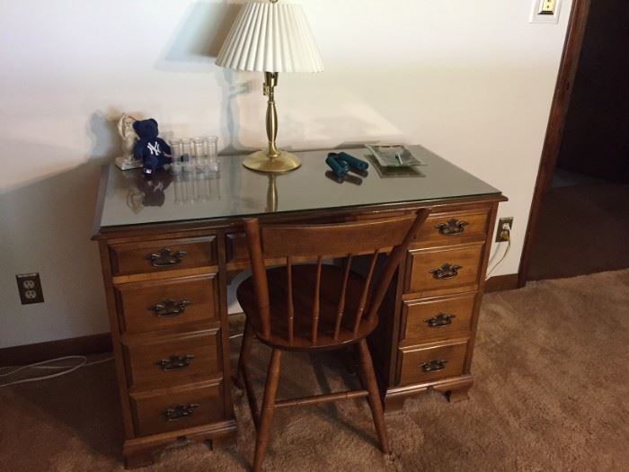 Smaller sized solid wood desk with chair and glass top.  Dimensions 30" height x 32" width x 22" depth.  Very good condition