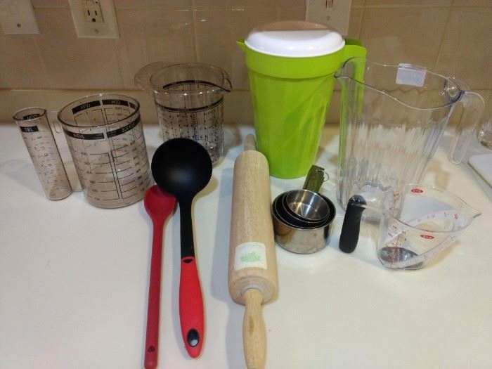 $10.00 Kitchen Lot #3 Water pitchers, measuring cups and spoons, ladle, and rolling pin