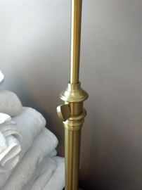 Gold lamp with white shade.  Adjustable