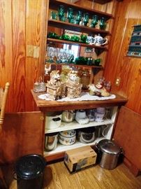 Beautiful green glass and cookie jars along with large pots and other kitchen gadgets