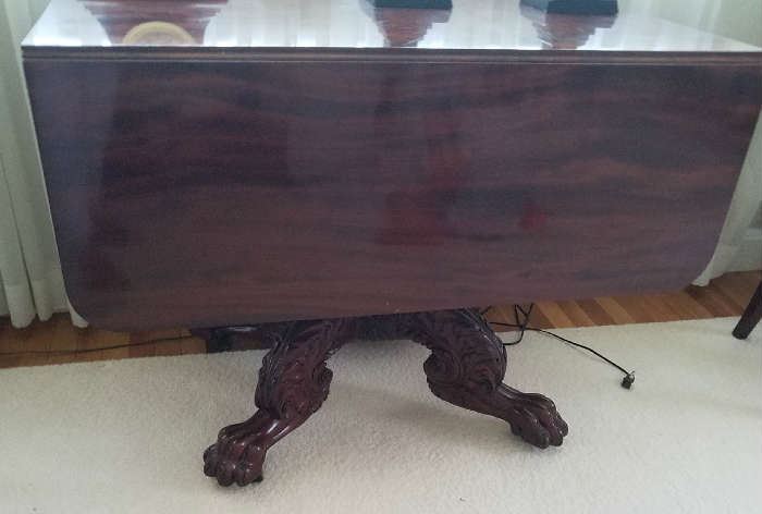 Mahogany Classical Drop Leaf Table w/elaborate carved base and lions paw feet.
