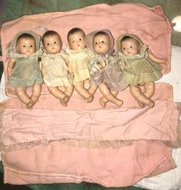 The Dionne Quintuplets. Toddler size, 8”. By Madame Alexander. Made of composition, in good condition. The arm and leg rubber bands are stretched out and need to be replaced. Original clothes and blankets.