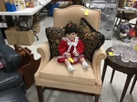 Beige chair - and that’s a very alive looking Doll