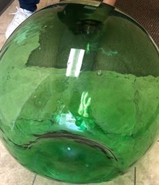 Demijohn Bottle Dark green in color Approximately 4 to 5 gallons in basket that opens freely