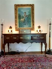 Vintage mahogany sofa table, with antique English writing box, vintage pair of unusual stained glass/cast iron table lamps, original oil on canvas of young mädchen mit schaf, flanked by a pair of vintage Kreiss torchieres.