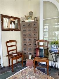 Artisan made wall mirror with birch bark and pinecones, 2 of a set of 6, Frenchy-style oak chairs with rush seats, one of a pair of golden foo dogs on travertine bases, one of a pair 3-legged accordion side tables, with zinc tops, one of a pair of those lovely 24-drawer storage chests.