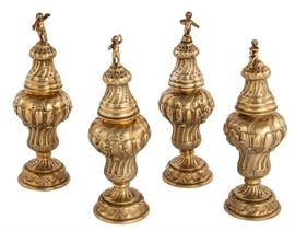 Lot 5 A set of four German silver-gilt casters  
With pseudo marks, probably Hanau, early 20th century 
Each with different putto finial  