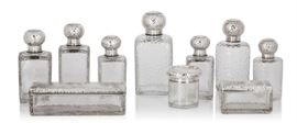 Lot 15 An assembled French martelé silver and glass ten piece vanity service  
By Auguste Guyot, Gustave Keller and possibly Emile Puiforcat, Paris, 20th century 
Comprising: seven bottles, two boxes and a jar  