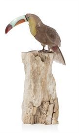 Lot 37 A carved hardstone figure of a toucan  
Marked for Peter Muller, Brazil, modern 
On petrified wood base, toucan lacking lower portion of beak.  