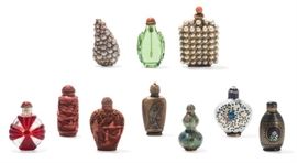 Lot 69 An assembled varied group of ten Chinese snuff bottles  
19th-20th century 
Comprising: a green glass bottle, a molded red overlay glass bottle, two pearl-inset bottles, two enameled bottles, a black lacquer bottle, a carved horn bottle and two cinnabar lacquer style resin bottles.  