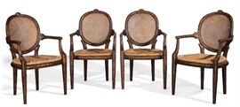 Lot 114 A set of four rustic carved wood and cane paneled armchairs 
post 1950 
Each with a slip in rush seat.  