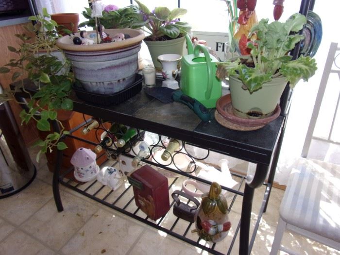 Metal baker's/gardener's rack with glass shelves and stone tile shelf.