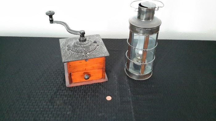 Antique coffee grinder with dovetail and ornate cast iron top, and vintage-look oil lamp.
