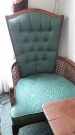 Vintage tufted chair with rattan arms.