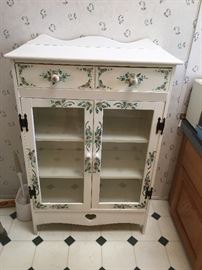 Cute painted cabinet with one drawer and 3 shelves behind glass doors.