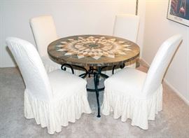 Arhaus marble table top with cast iron legs with four covered chairs - 48" Diameter x 30" Height.