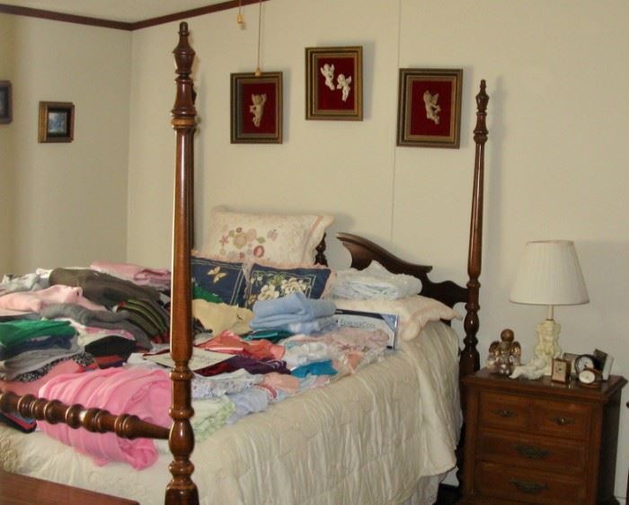 Four poster bed with nightgowns and designer clothing