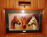 Framed horse print with light.