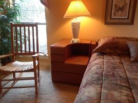 Kind headboard is in three sections with curved side tables.