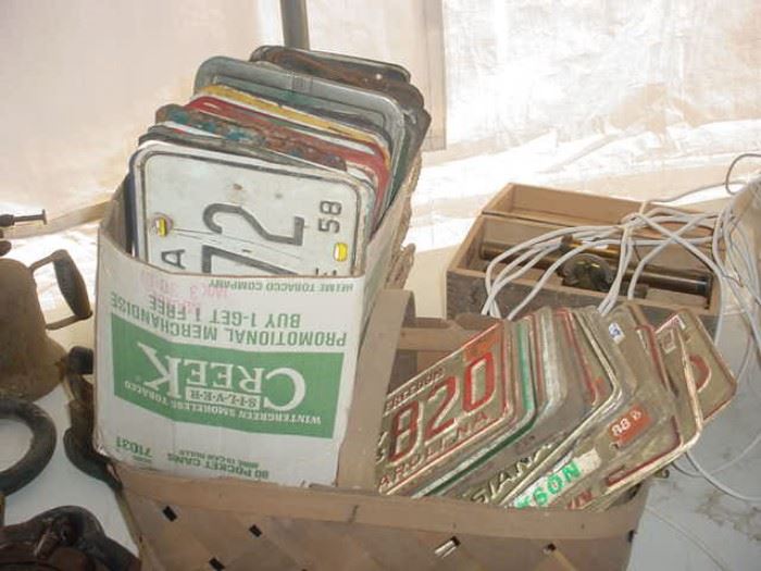 boxes of old auto license plates from the 1940's forward