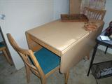1950's blonde dining table with four chairs.  Has two leaves. This is a solid piece of furniture.