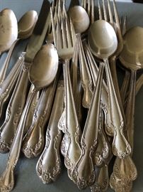One of about 4 partial sets of flatware in stainless and plate