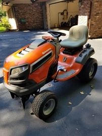 Husqvarna tractor with snow blade. Model YTH24V42LS. 24 Hp Kawasaki engine. Accommodates a 42-inch mower deck. Snow blade is 48-inches by 14-inches. 145 hours.