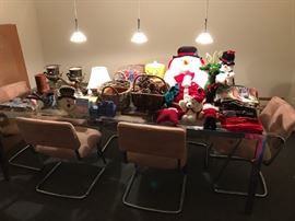 Retro glass-top dining room table and chairs -- covered with holiday and household items.